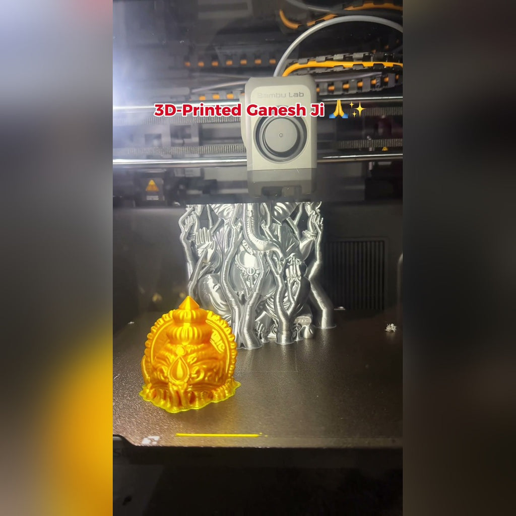 Ganesh Ji idol being 3D-printed in metallic silver on a Bambu Lab printer, gold crown beside it