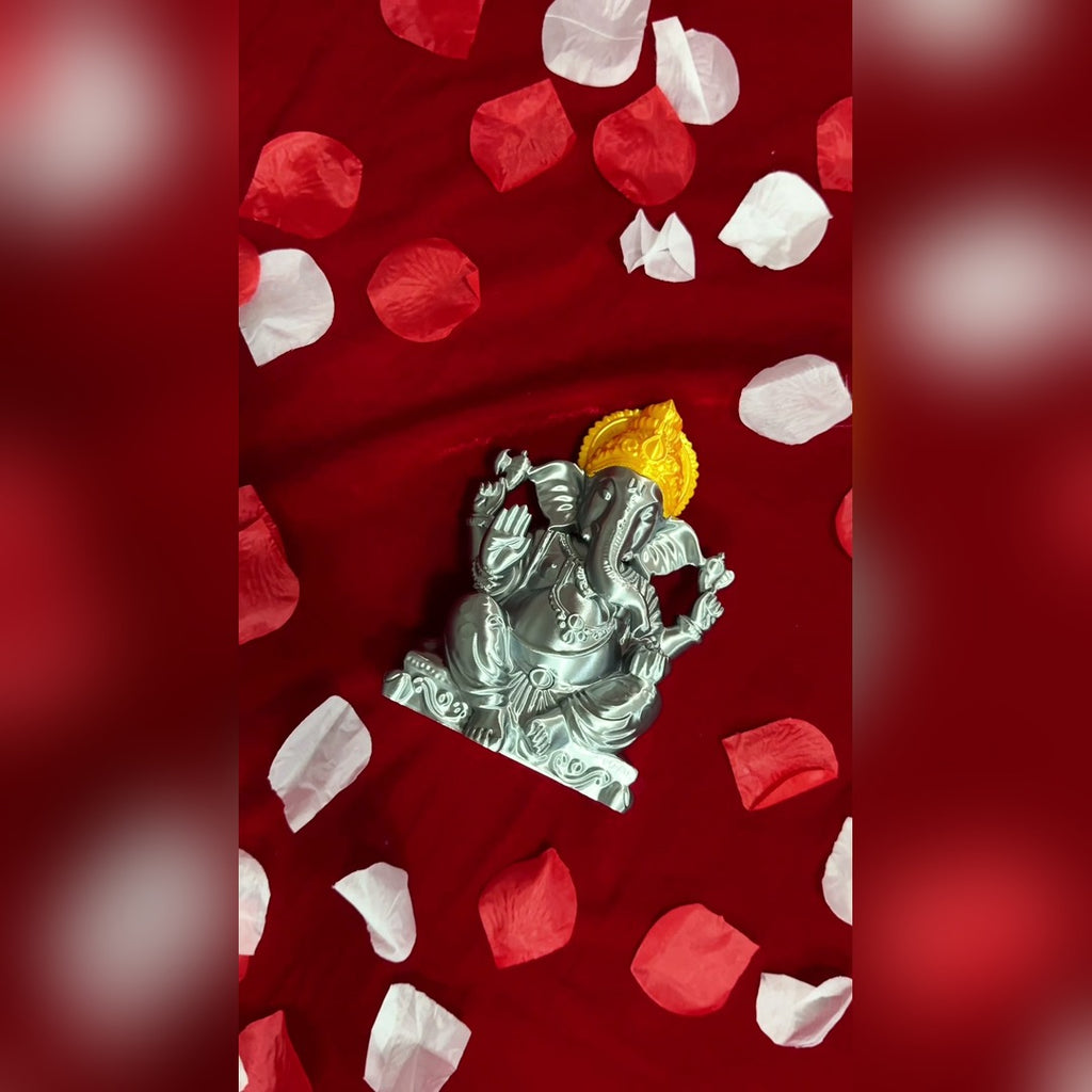 Top-down view of the 3D-printed Ganesh Ji idol surrounded by red and white flower petals