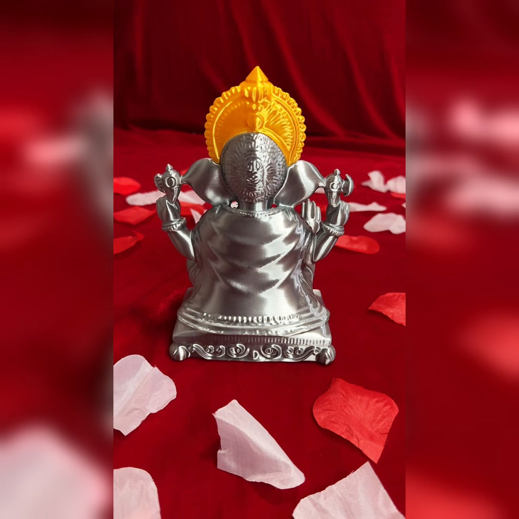 Back view of the 3D-printed Ganesh Ji idol, showing the back of the silver figure, draped detailing, and gold crown