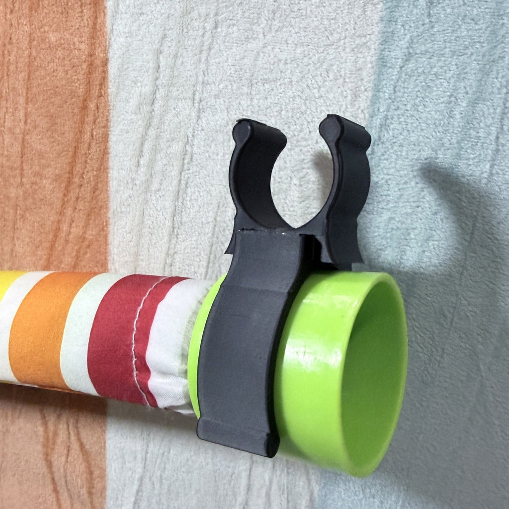 Black rod holder clip gripping a colorful backdrop stand rod
